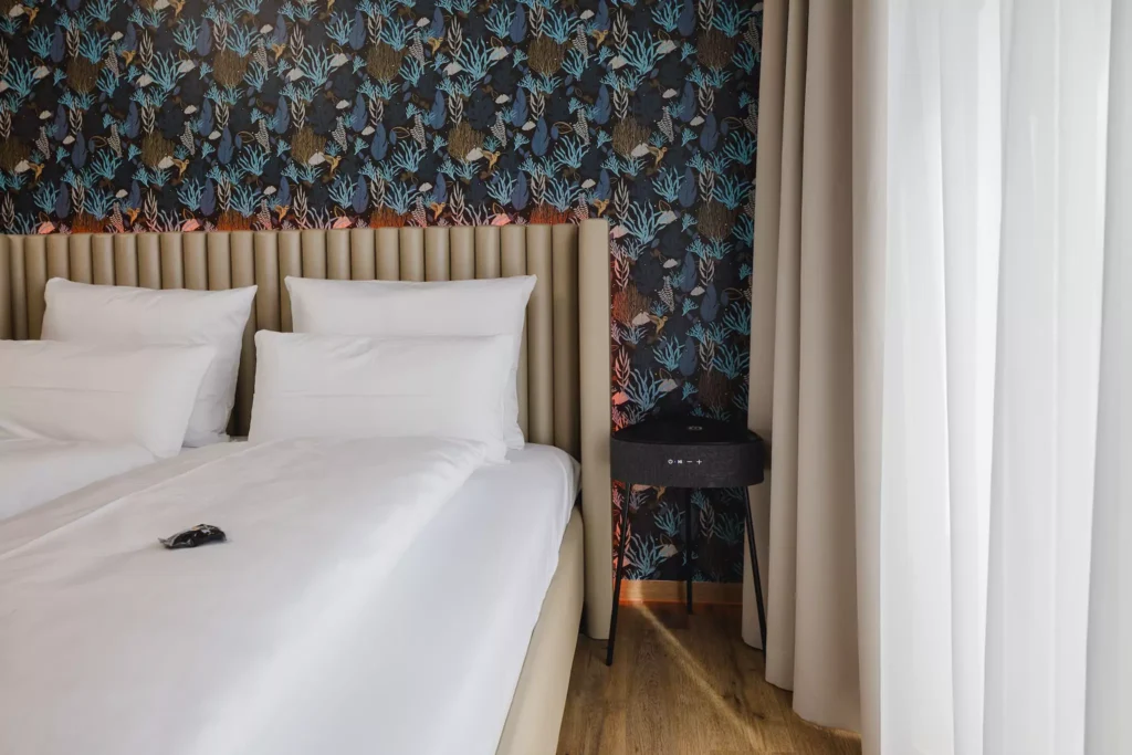 Großes Doppelbett mit Lautsprecher in Serviced Apartment Hotel