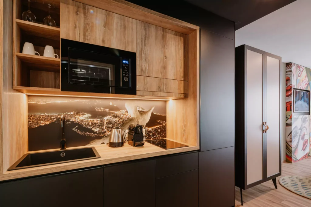 Schwarze Küche mit Holzdetails und Kaffemaschine