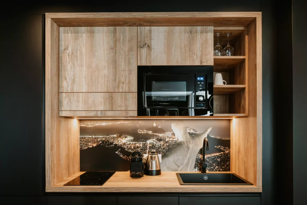 Schwarze Küche mit Holzdetails und Kaffeemaschine