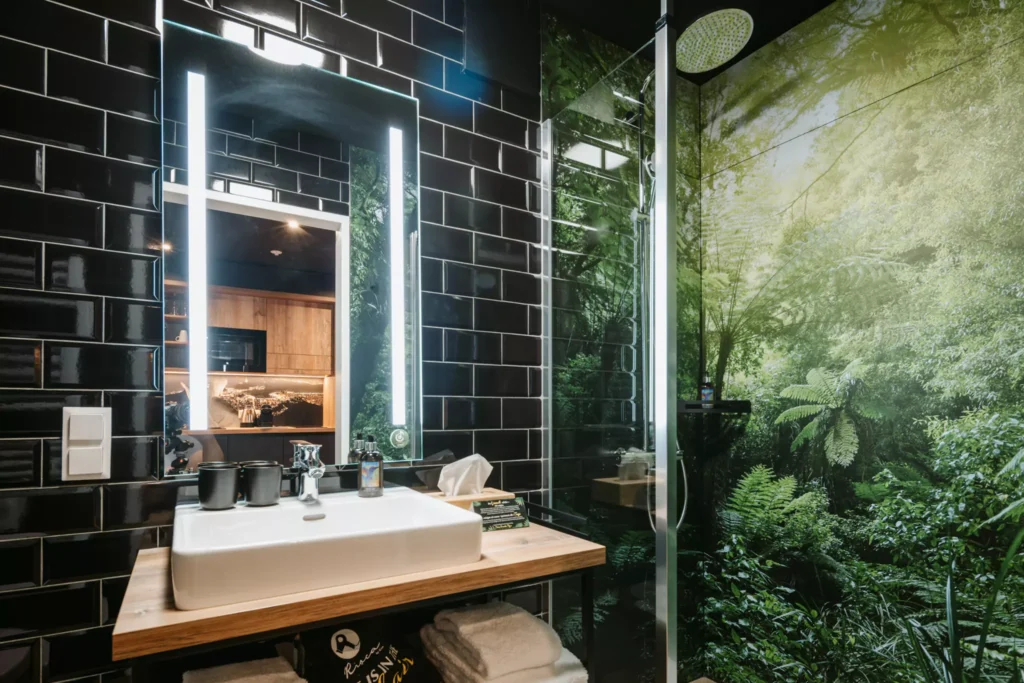 Badezimmer mit schwarzen Fließen und Regendusche