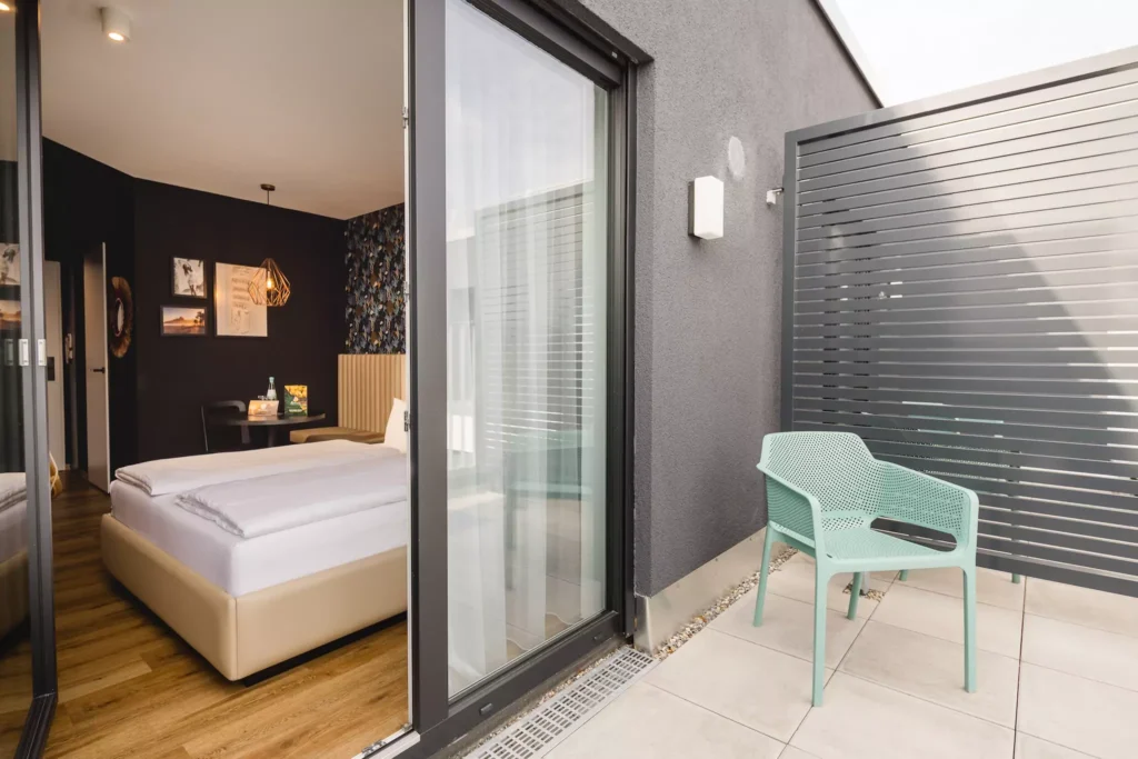 Großes Hotelzimmer mit Bett und Balkon in Offenbach