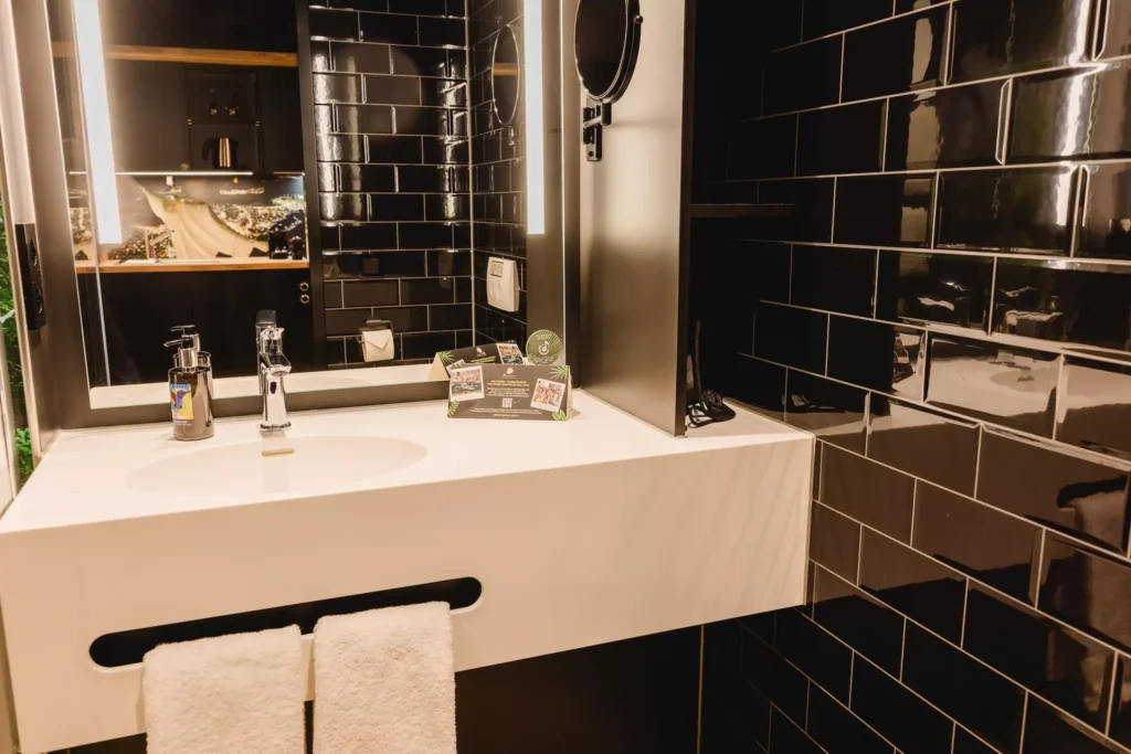 Bad mit Waschbecken und großem Spiegel in Serviced Apartment