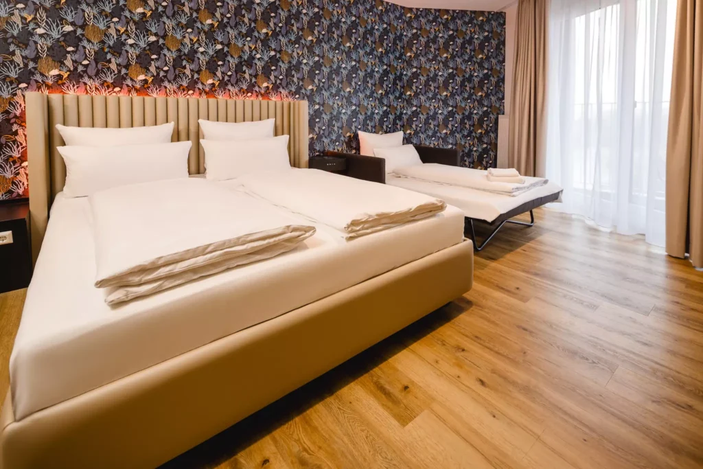 Großes Bett und Schlafsofa in Apartment Hotel