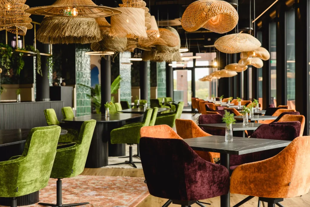 Deckenlampen und grüne und orange Samtstühle