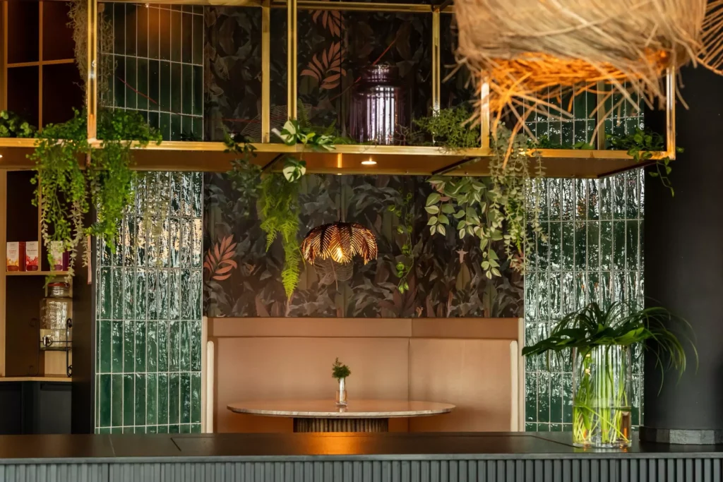 Sitzecke mit goldener Lampe und Dschungel Dekoration in modernem Designhotel