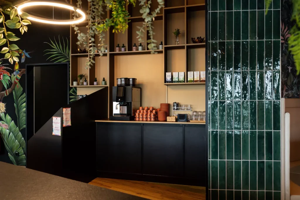 Kaffeemaschine mit Espresso Tassen und grünen fließen im Vordergrund in modernem Restaurant