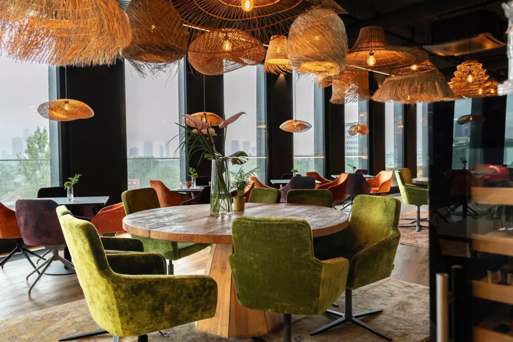 Großer runder Tisch mit grünen Stühlen