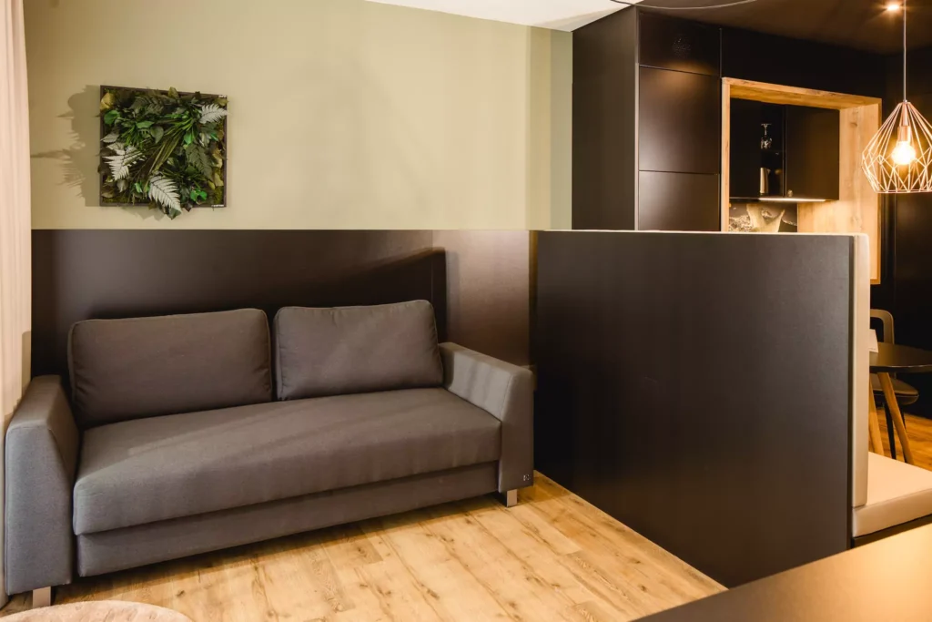 Graues Sofa in modernes Hotelzimmer für vier Personen