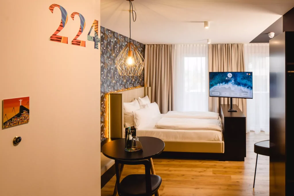 Modernes Hotelzimmer mit Doppelbett, TV und Tisch