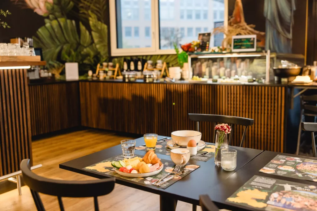 Frühstück in modernem Hotel mit Ei, Croissant, frischem Gemüse und Früchten