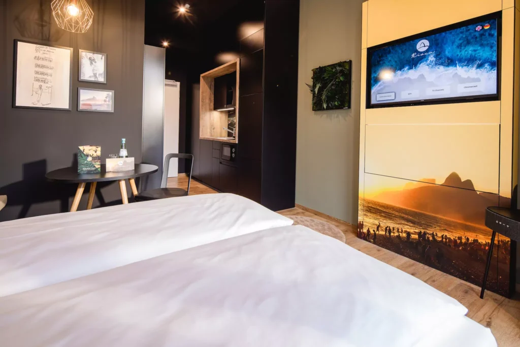 Modernes Hotelzimmer mit Doppelbett, TV und Küche