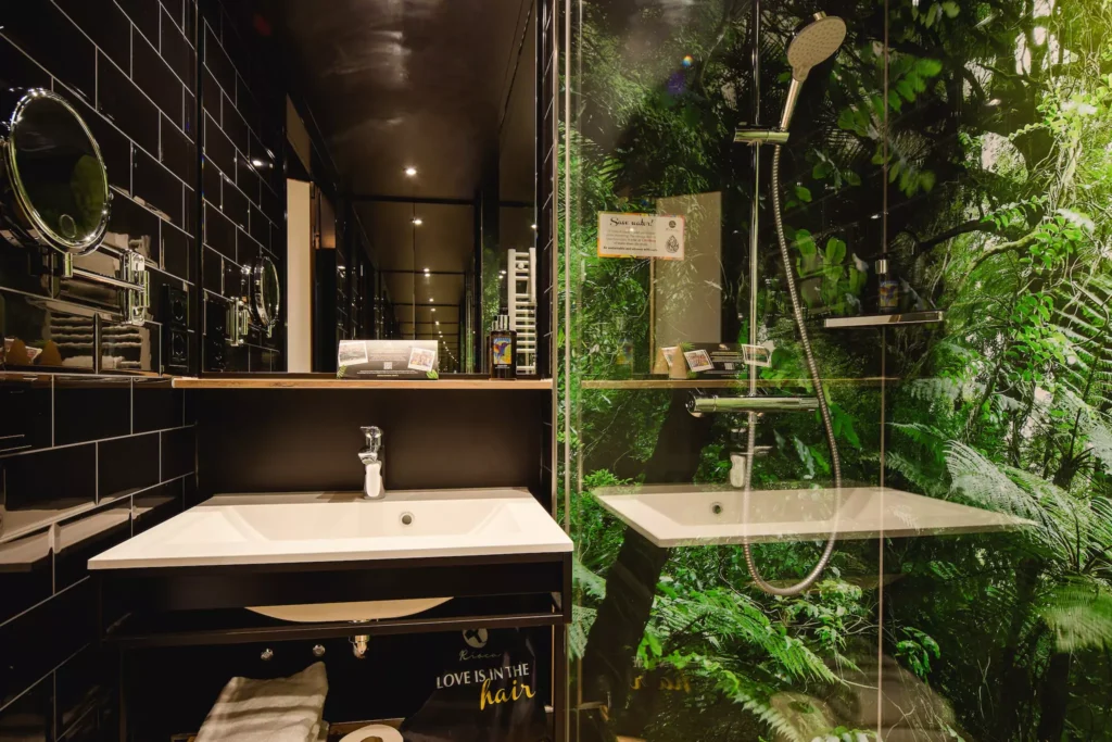 Badezimmer mit Waschbecken und Regendusche in modernem Hotelzimmer