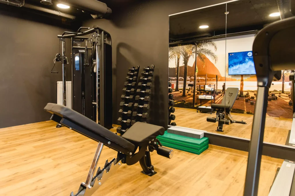 Fitnessraum mit Laufband, Hanteln und Spiegel