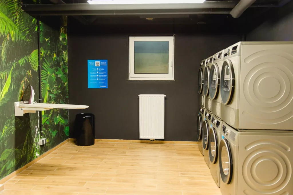 Waschraum mit acht Waschmaschinen und Bügeleisen