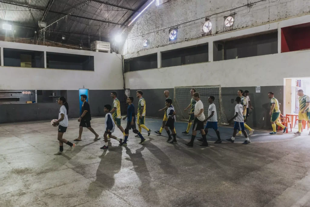 Kinder der Fußballschule und Gegner laufen in die Halle ein.