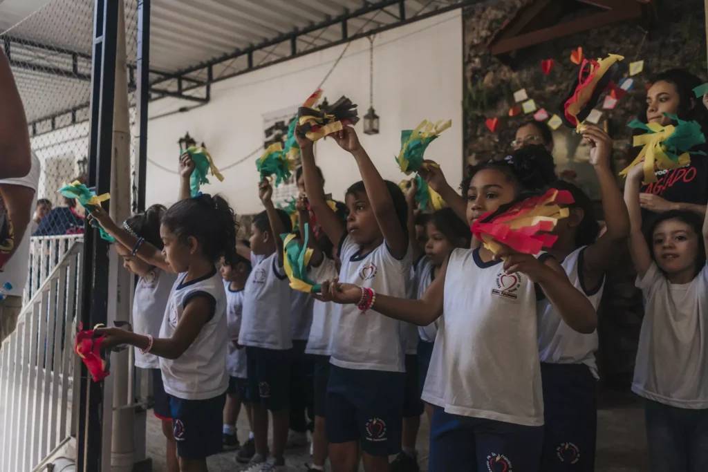 Kinder halten Pompoms in die Luft