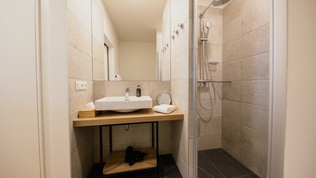 Badezimmer mit Waschbecken in weiß und Regendusche