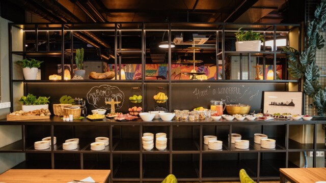 Frühstücksbuffet mit Früchten, Croissants und Eier vor schwarzer Wand