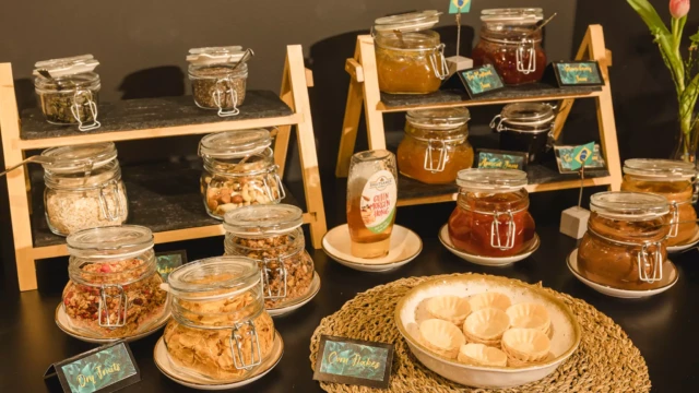 Frühstücksbuffet mit verschiedenen Aufstrichen, Marmelade und Müsli zur Selbstbedienung.