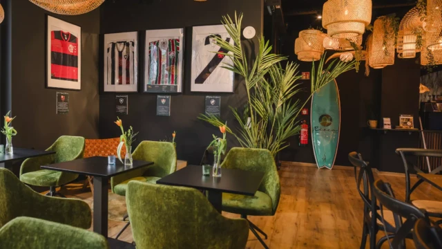 Frühstücksbereich eines Hotels mit grünen Stühlen und schwarzen Tischen