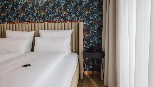 Großes Doppelbett mit Lautsprecher in Serviced Apartment Hotel