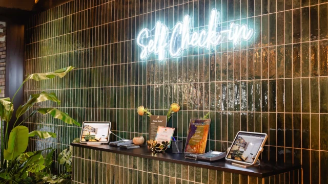 Self-Check-In vor Wand mit grünen Fliesen