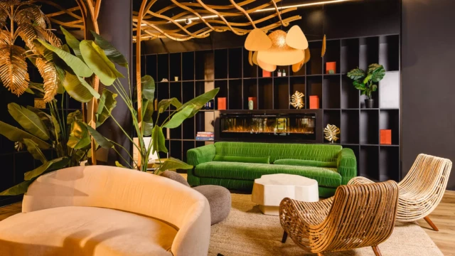 Grünes Sofa vor Kamin und bunter Dekoration