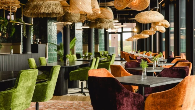 Deckenlampen und grüne und orange Samtstühle