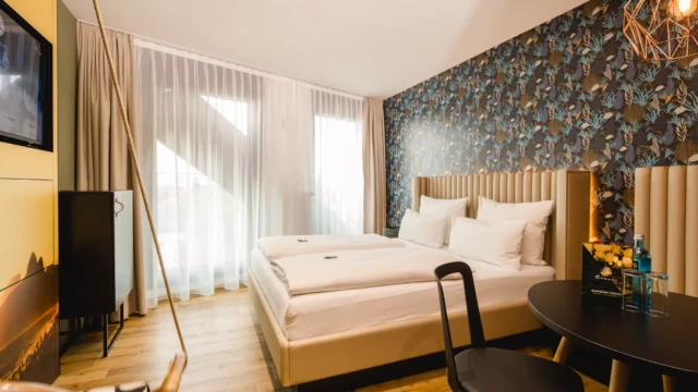 Weißes Doppelbett vor Großem Fenster