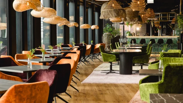 Orange Stühle und schwarze Tische